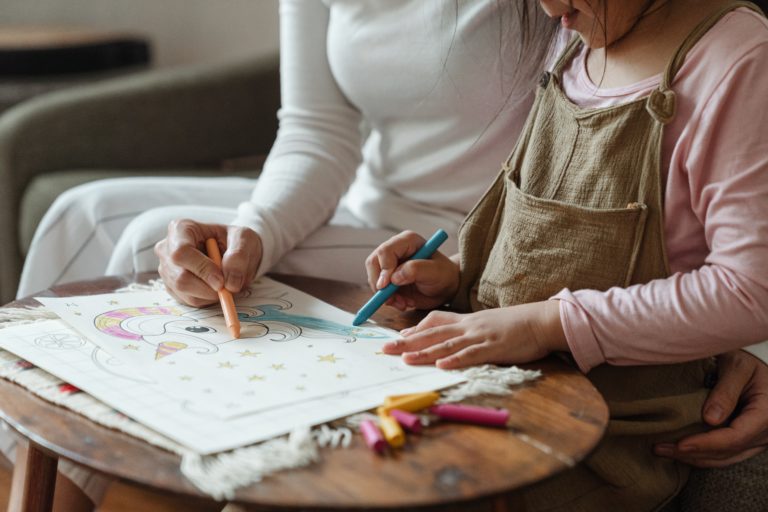 Frau malt mit Kind etwas aus